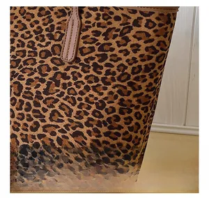 Detailed macro view of leopard print tote bag texture with brown suede finish and leather trim