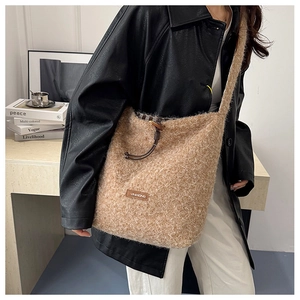 Close-up of brown wool bucket bag featuring leather VINXIONG logo and drawstring closure