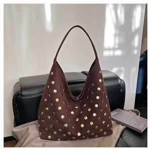 Detail of dark brown suede Hobo bag with decorative gold metal rivets and soft texture