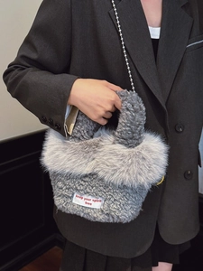 Gray faux fur handbag with silver bead chain strap and white fabric quote label