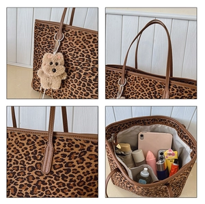 Detail view of large leopard print tote bag interior with teddy bear charm and brown handles