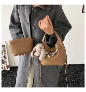 Brown leather bucket bag set with luxury pebble grain and cute rabbit plush charm detail