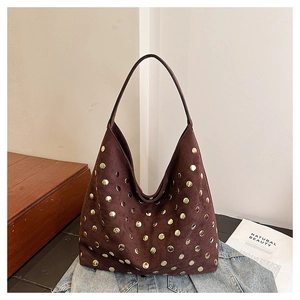 Detail of dark brown suede Hobo bag with decorative gold round metal rivets