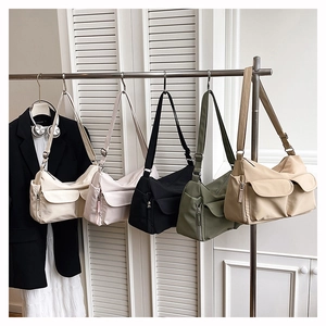 Five nylon crossbody bags in varied colors displayed on a rack with multiple pockets