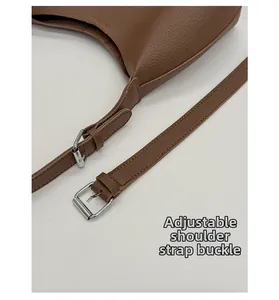 Detail of brown litchi pattern leather bucket bag with adjustable silver metal buckle