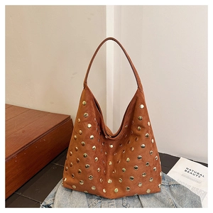 Close-up of brown suede hobo bag featuring dense gold rivet detailing and large capacity