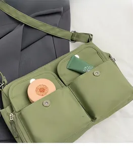Detail of light green nylon crossbody bag with dual magnetic pockets and zipper closure