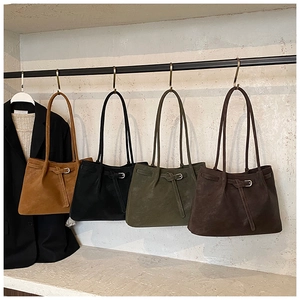 Hanging display of suede tote bags with belt buckles in four premium autumn colors