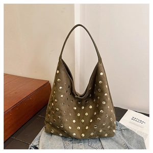 Detailed close-up of olive green suede tote bag with decorative golden stud rivets