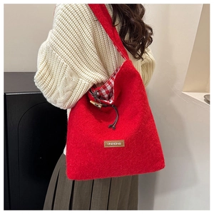 Detail view of red wool tote bag showing red checkered lining and horn buckle closure