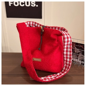 Detail view of red wool tote bag showing toggle closure and red gingham lining texture