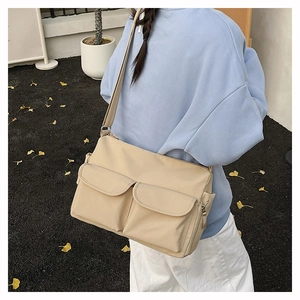 Detail of light khaki nylon crossbody bag featuring double front flap pockets