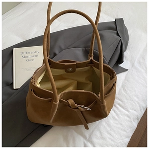 Close-up of brown tote bag showing magnetic metal clasp and drawstring detail