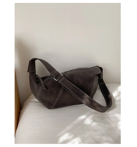 Detail of vintage dark brown hobo bag with contrast white stitching and suede texture