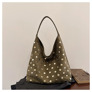 Close-up of olive green suede tote bag with decorative metal rivets and wide handle