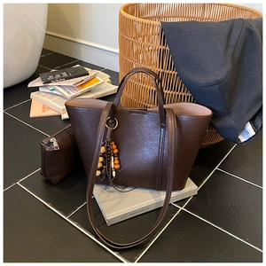 Dettaglio della borsa tote in ecopelle marrone scuro con pochette e ciondolo a nappa