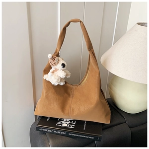 Detail of camel brown tote bag with premium stitching and a cute teddy bear charm