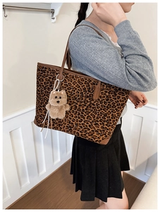Close-up of leopard print tote bag featuring a cute brown plush bear charm detail