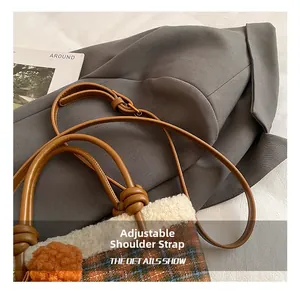 Detail of adjustable knotted leather strap on a plush checkered bucket bag for winter