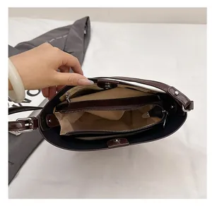 Detailed interior of vintage brown leather handbag showing compartments and zipper pocket