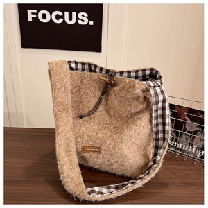 Close-up of wool tote bag with soft plush texture, check lining and toggle closure