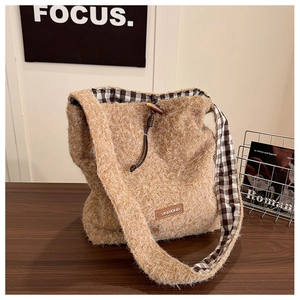 Detailed view of brown plush tote bag featuring drawstring closure and checkered lining