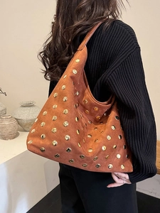 Retro brown suede tote bag with gold rivets shown in a stylish over-the-shoulder view