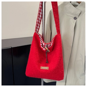 Detail of red fleece tote bag featuring horn toggle closure and brand leather patch