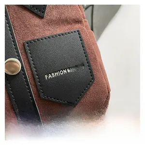 Detailed macro view of brown suede fabric with black leather trim and silver rivets