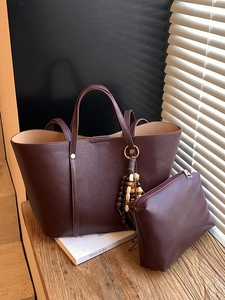 Borsa tote bordeaux in pelle con pochette coordinata e nappina di perline su legno