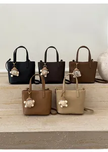 Five small tote bags in neutral colors with litchi texture and plush pendant charms