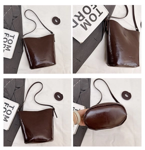 Macro detail of dark brown leather bucket bag with adjustable strap and oval base