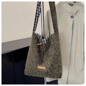 Detail of green fuzzy tote bag showing shaggy faux mohair texture and horn button closure