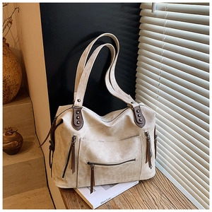 Détail du sac cabas rétro avec poches latérales zippées et rivets métalliques sur l'anse