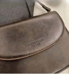 Detail of vintage brown matte leather texture and fine stitching on the flap handbag