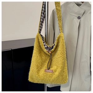 Detail of yellow plush tote bag with black-white checkered lining and horn button