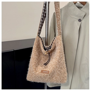 Detail of wool tote bag featuring soft plush texture, drawstring and check lining