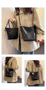 Detail of black glossy bucket bags showing premium leather texture and two size options