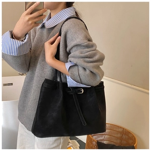 Mirror selfie showing the large black matte leather tote bag and its fit for shoulder wear