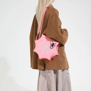 Dettaglio della borsa rosa con ragnatela e ricamo a ragno nero su pelle sintetica PU