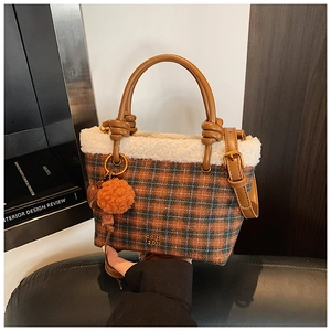 Détail du sac cabas en tweed à carreaux avec bordure en fausse fourrure et pendentif
