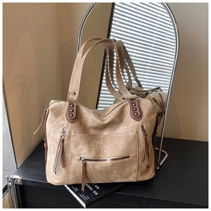 Détail du sac polochon en toile kaki avec poignées en cuir et rivets métalliques vintage