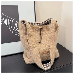 Detail of light camel plush tote bag with checkered lining and toggle closure