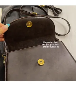 Detail view of the brown retro crossbody bag showing the magnetic snap closure system