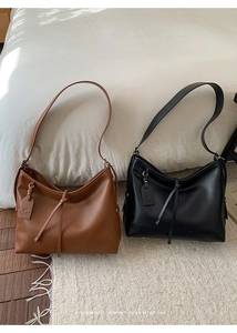 Vue détaillée de cabas minimalistes marron et noir avec cordons noués sur tapis doux
