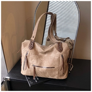 Détail du sac cabas en toile kaki avec fermetures éclair à pompons et rivets en métal