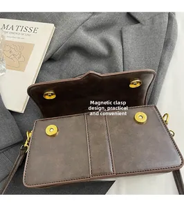 Detail view of the secure magnetic clasp and gold hardware on a brown crossbody bag