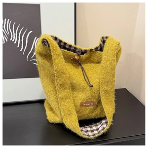 Detail of mustard yellow fuzzy tote with wooden toggle closure and plaid lining texture