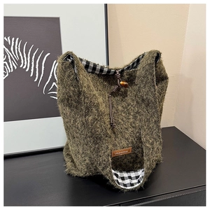 Detail of wool tote bag showing soft plush texture, green faux fur and plaid lining