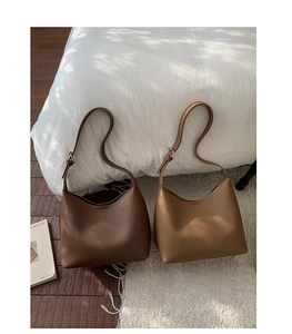 Close-up of minimalist crescent bucket bags in premium lychee grain leather with silver buckle